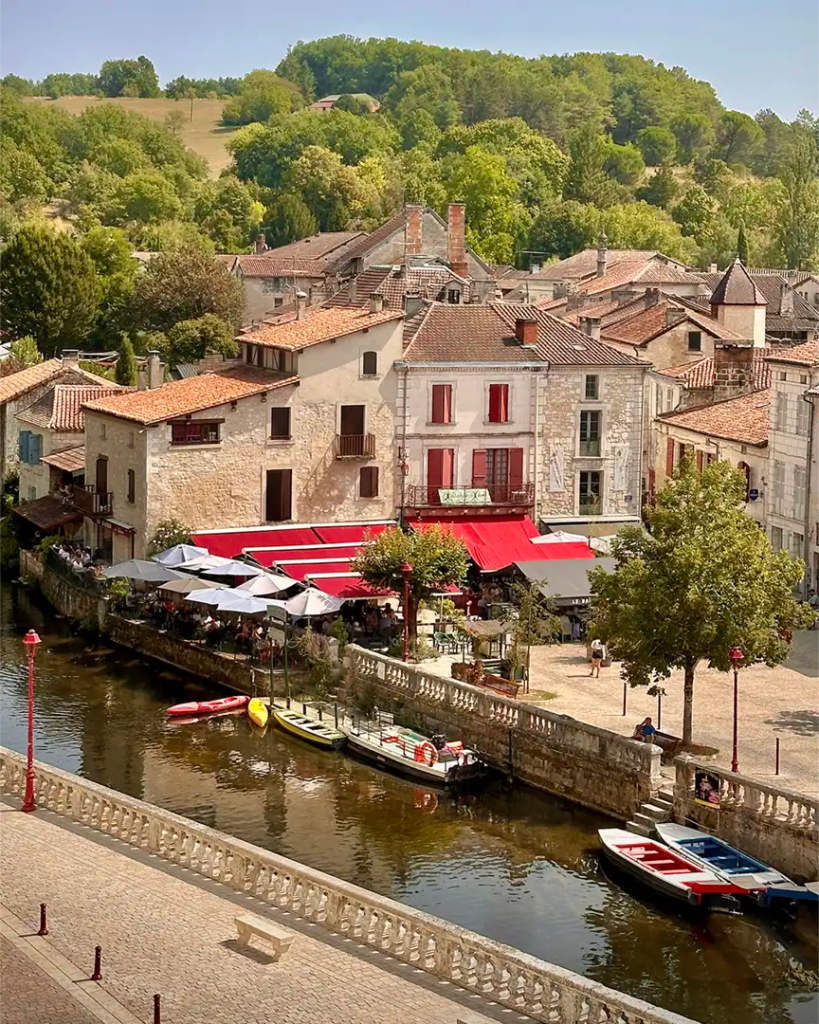 iew of Brantôme’s riverside promenade along the Dronne River, lined with stone buildings and cafés that embody the Dordogne’s charm and relaxed rhythm of life.